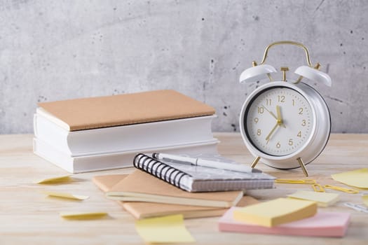 Alarm clock and books - time management and procrastination concept