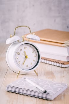 Alarm clock and books - time management and procrastination concept
