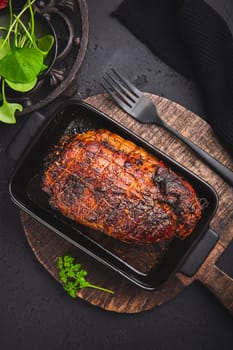 Roasted turkey breast in casserole on black background