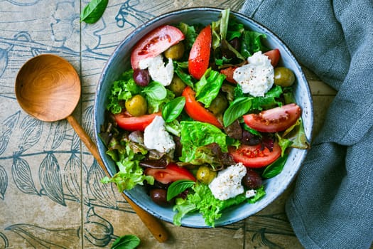 Burrata, Italian fresh cheese made from cream and milk of buffalo or cow. Burrata salad with tomatoes and salad mix. Healthy eating concept, keto diet salad