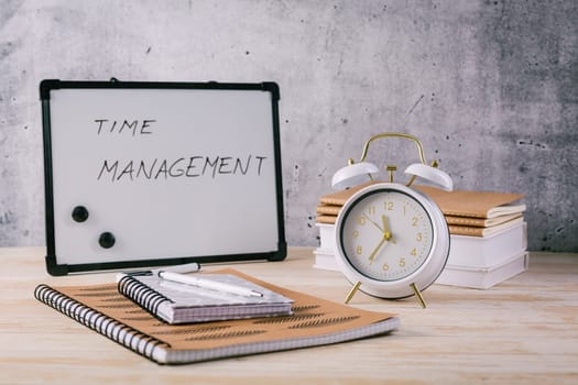 Alarm clock and books - time management and procrastination concept
