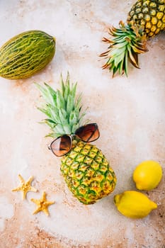 Summer concept - Pineapple hipster in sunglasses with melon and lemons, creative art fashionable vacation concept