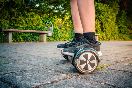 Teenager riding a hoverboard at schoolyard - self-balancing scooter, levitating board used for personal transportation
