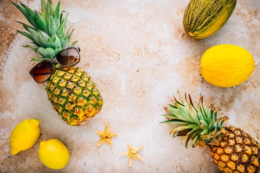 Summer concept - Pineapple hipster in sunglasses with melon and lemons, creative art fashionable vacation concept