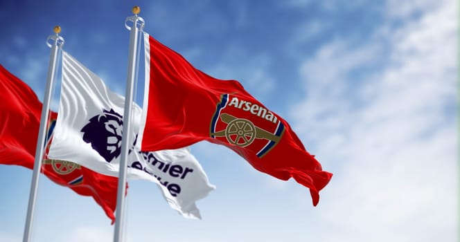 London, UK, July 18 2023: Arsenal Football Club and Premier League flags waving on a clear day. illustrative editorial 3d illustration render. Rippled Fabric. Selective focus
