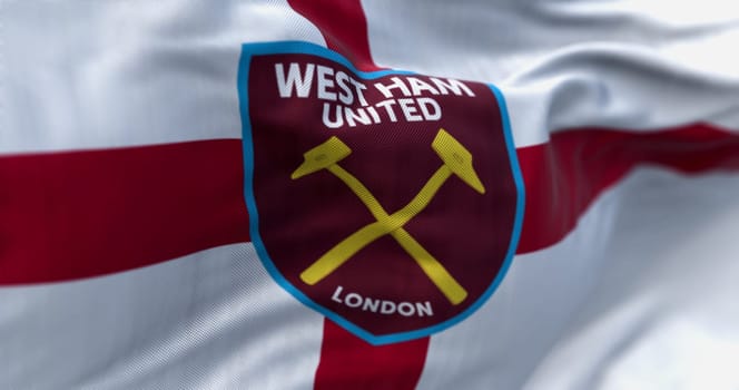 London, UK, July 3 2022: West Ham United F.C. flag waving in the wind on a clear day. English football club based in London. Illustrative editorial 3d illustration render. Selective focus