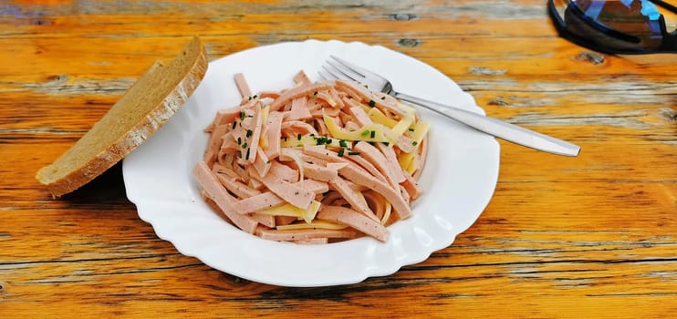 A plate with Swiss sausage salad and bread