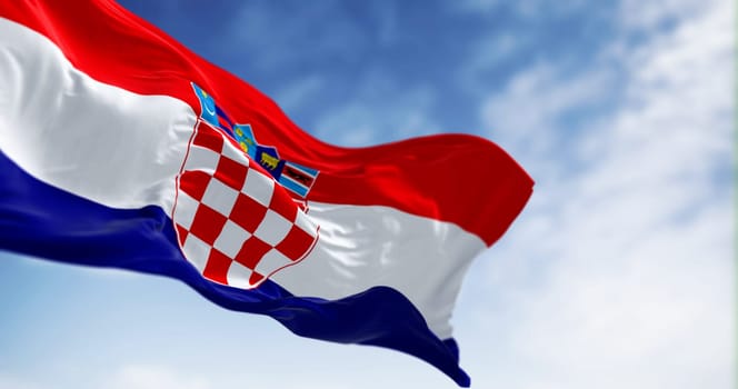 The national flag of Croatia waving in the wind on a clear day. Red, white and blue horizontal stripes with coat of arms in center. 3d illustration render. Fluttering fabric. Selective focus