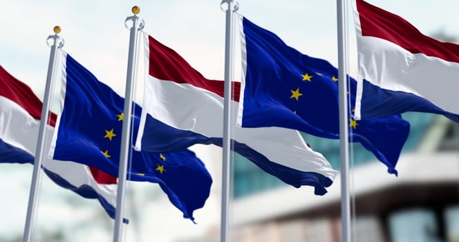 The flags of the Netherlands and the European Union waving in the wind on a clear day. The Netherlands became a member of the EU in 1958. 3d illustration render. Fluttering fabric. Selective focus