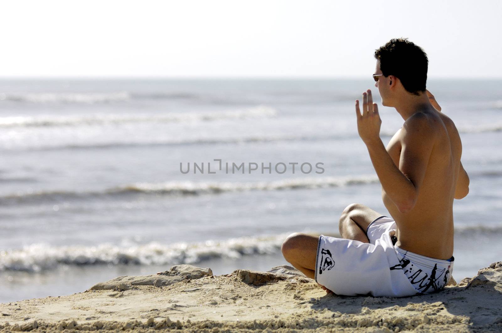 Man doing yoga on the beach