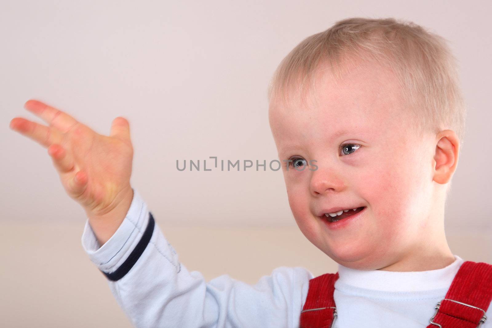 Portrait of a handicapped caucasian happy smiling boy with Down Syndrome.
