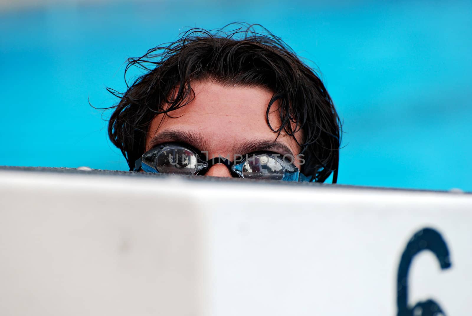 Swimmer behind a starting block