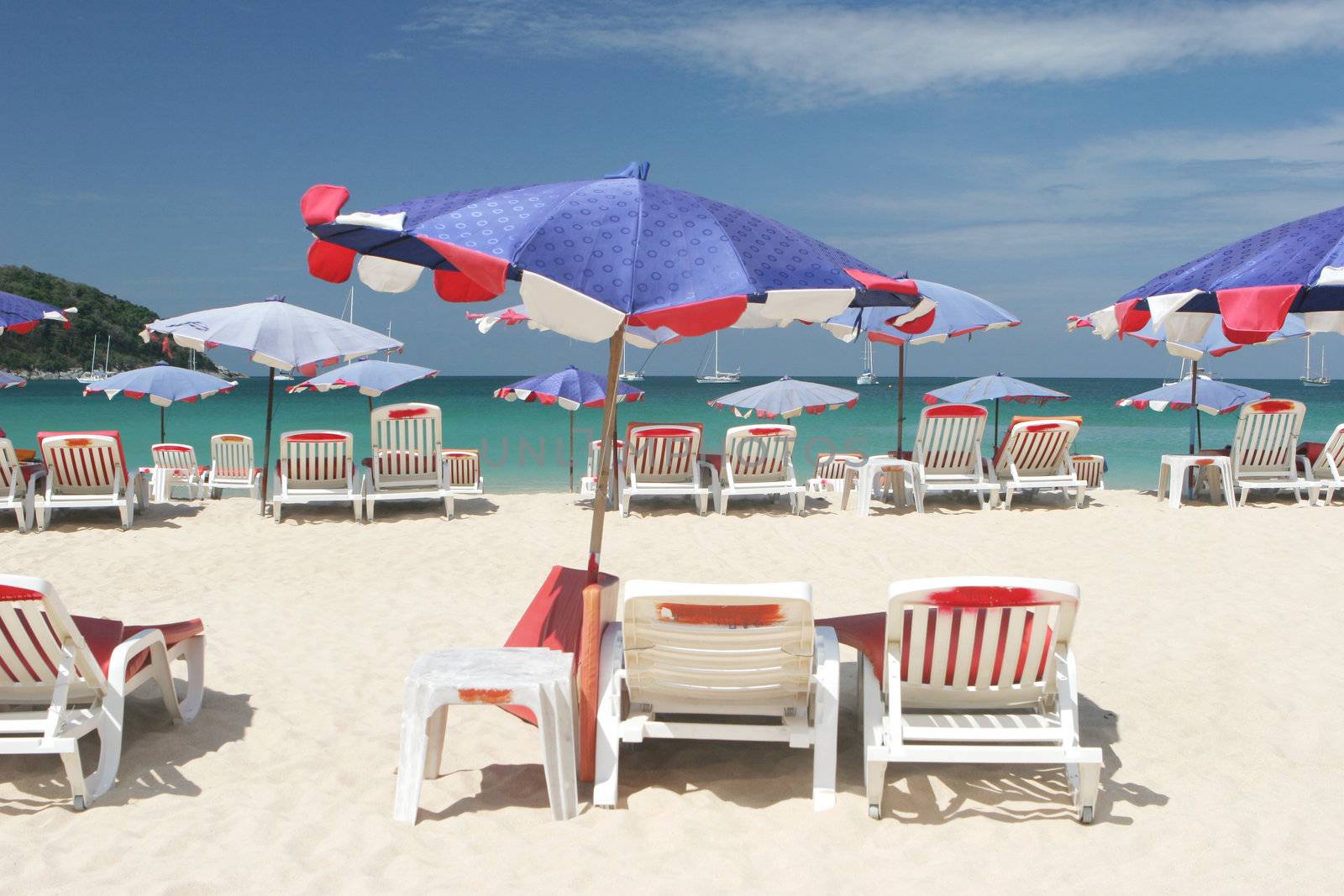 Rows of colorful beach chairs and umbrellas at the beach.