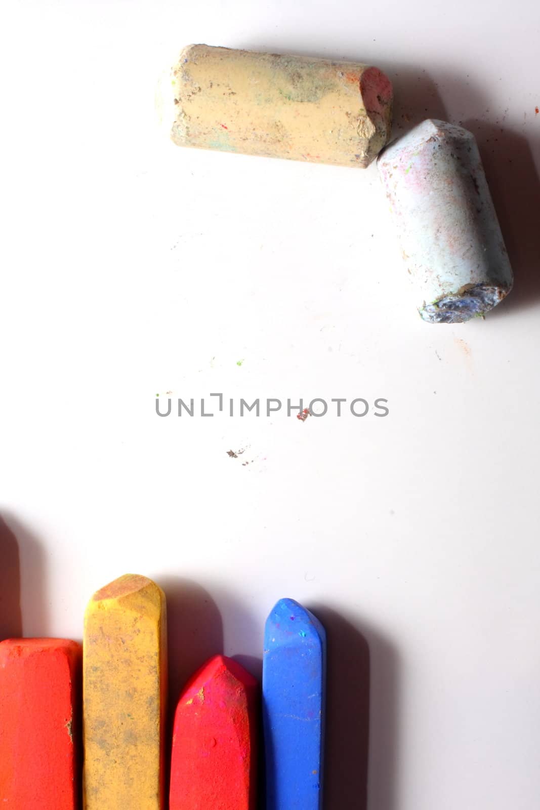A few used colored chalk pastels on white