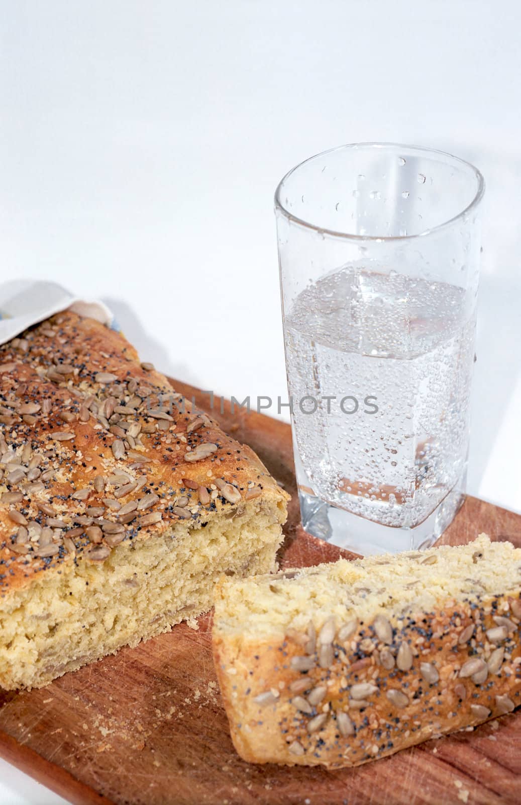 Cutting bread and glass of mineral water close up by mulden