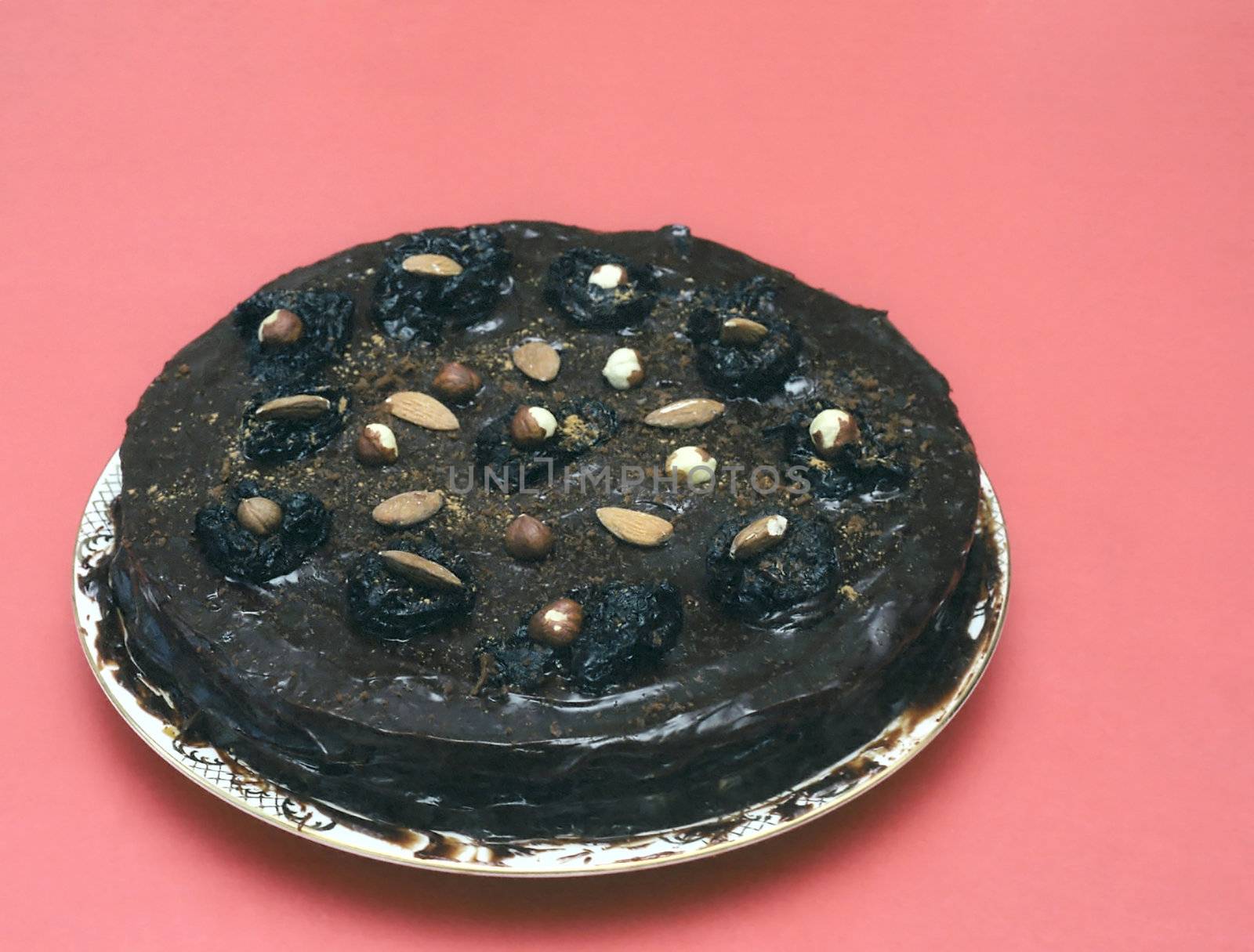 Black chocolate cake with nuts on red