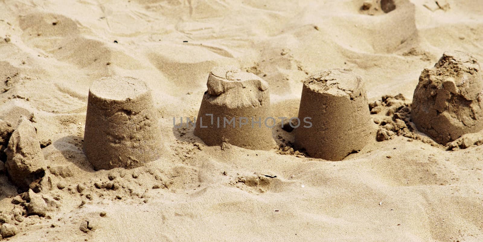 Crumbling deserted sand castles on a beach