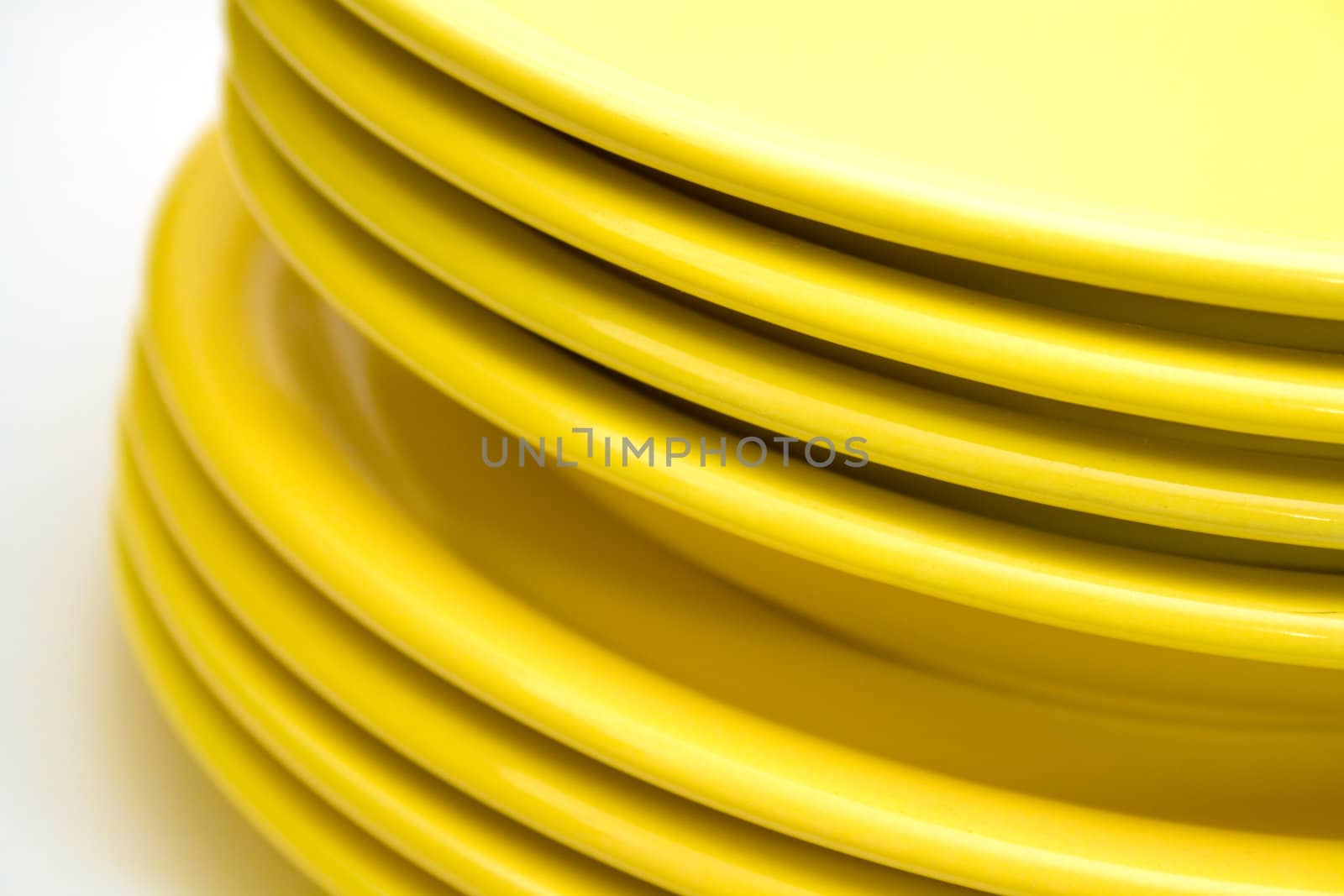 Stack of yellow plates isolated on white background.