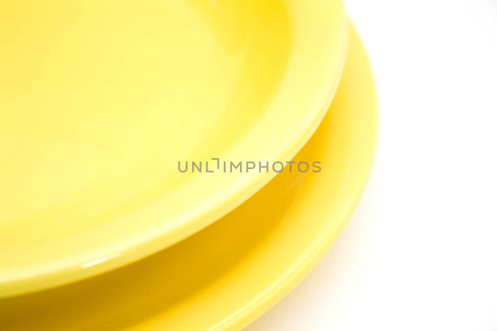 Two yellow plates isolated on white background.