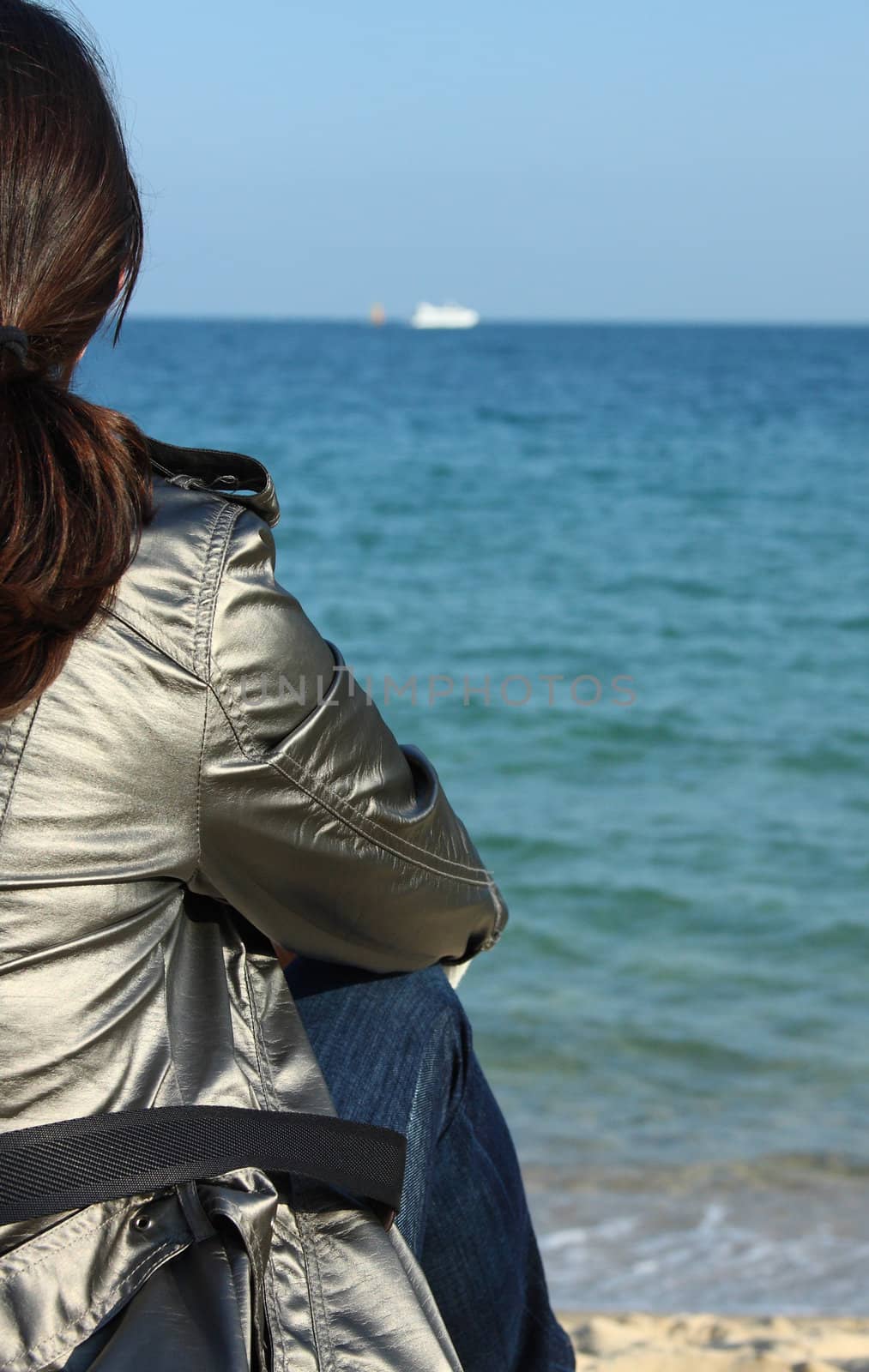 Woman sitting close to the sea in Barcelona.