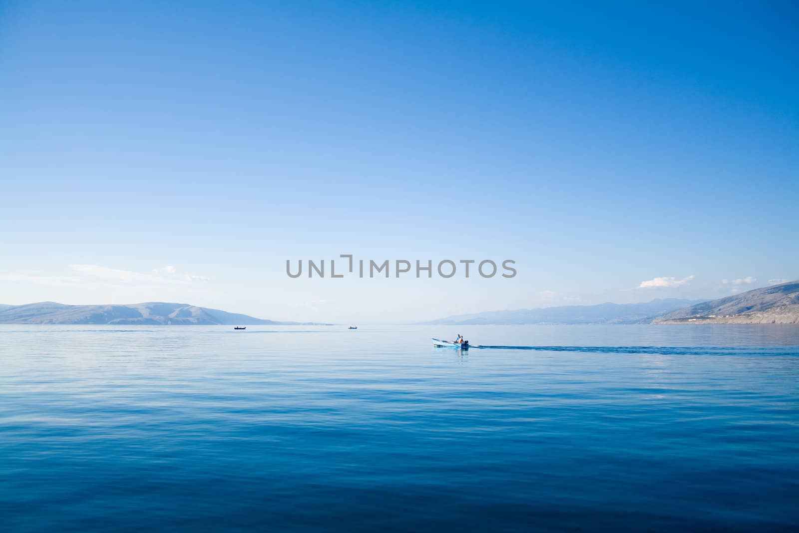 blue sky above a blue surface of the sea by nubephoto