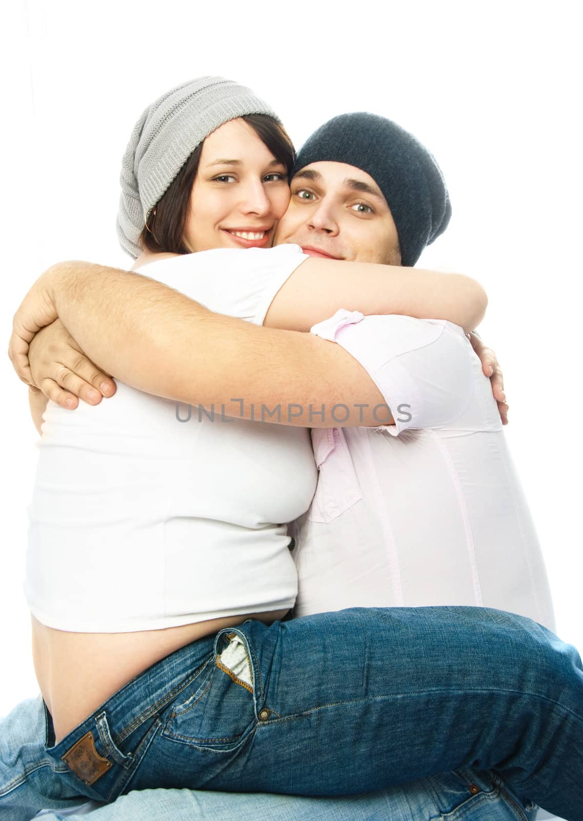 young pregnant woman and her excited husband embracing