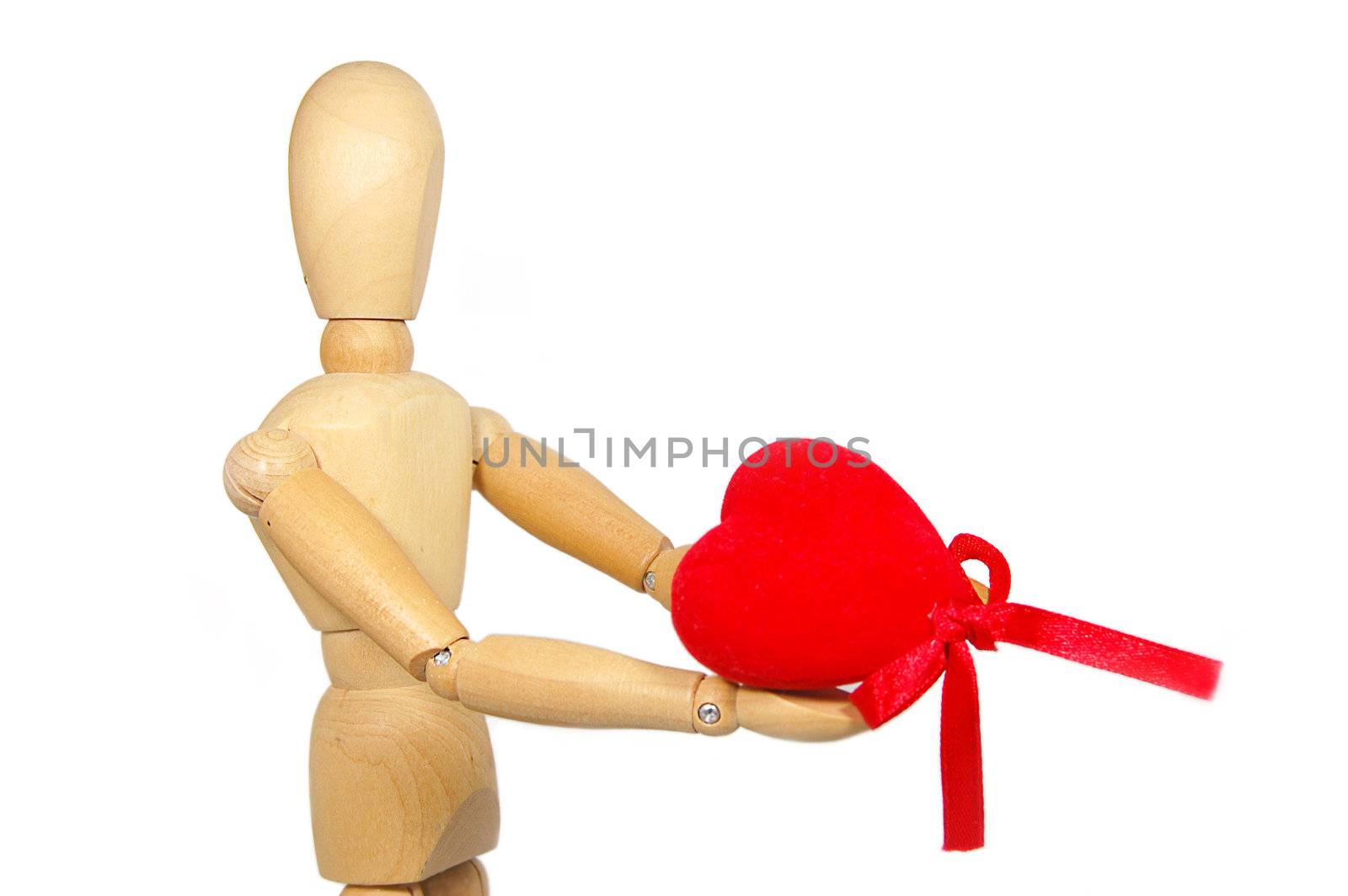 Wooden figurine man holding red fabric heart