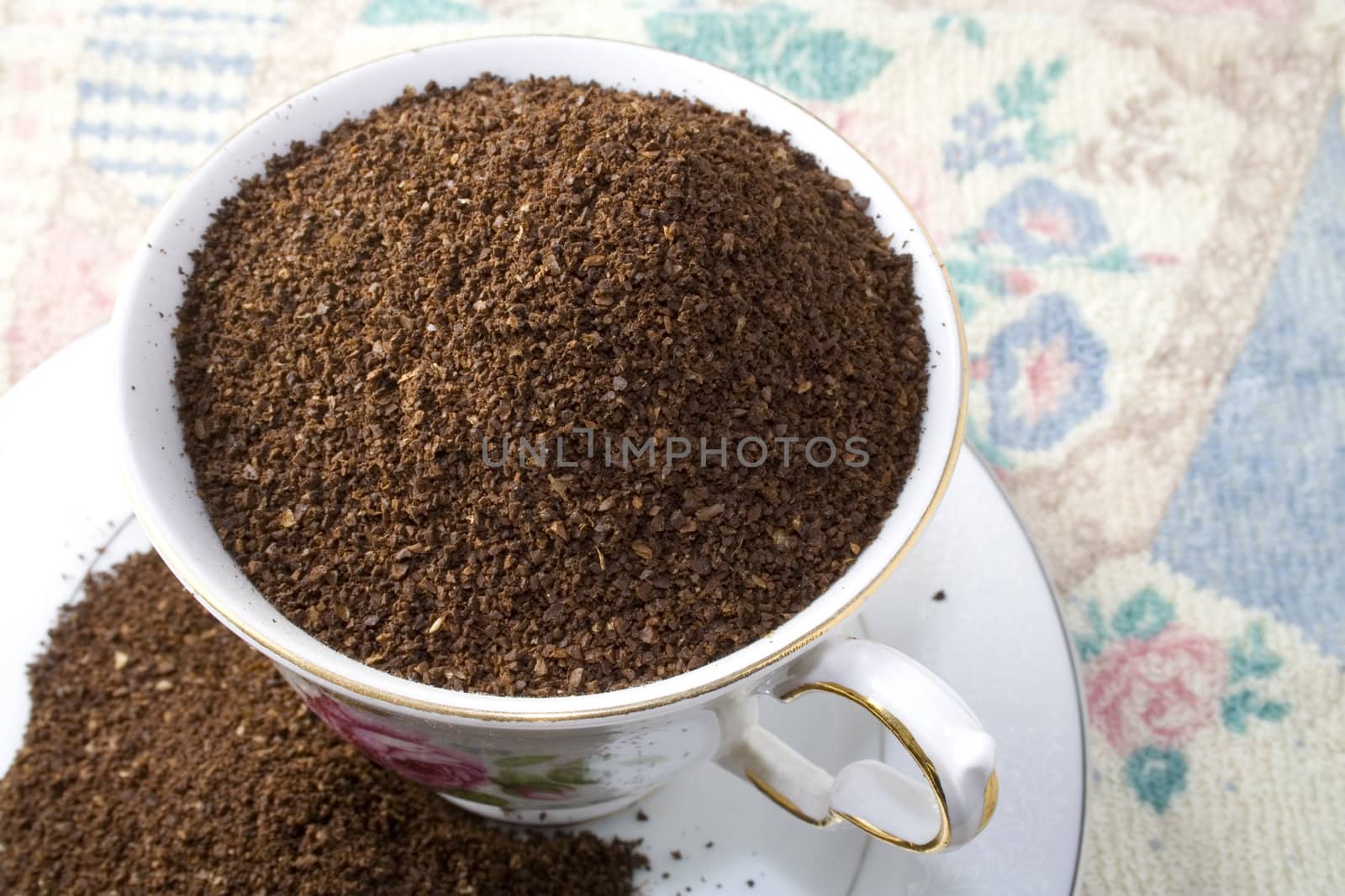 Raw ground coffee in cup with saucer