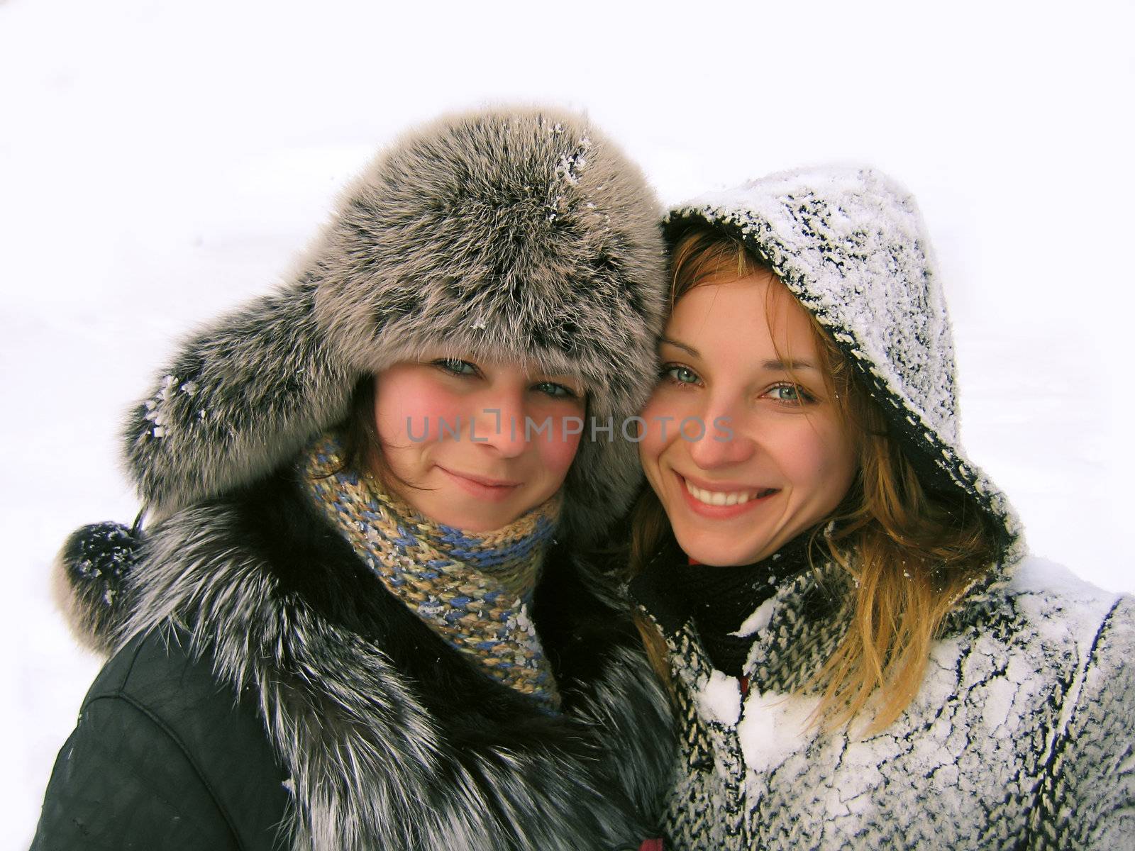Two smiling girls on snowy background