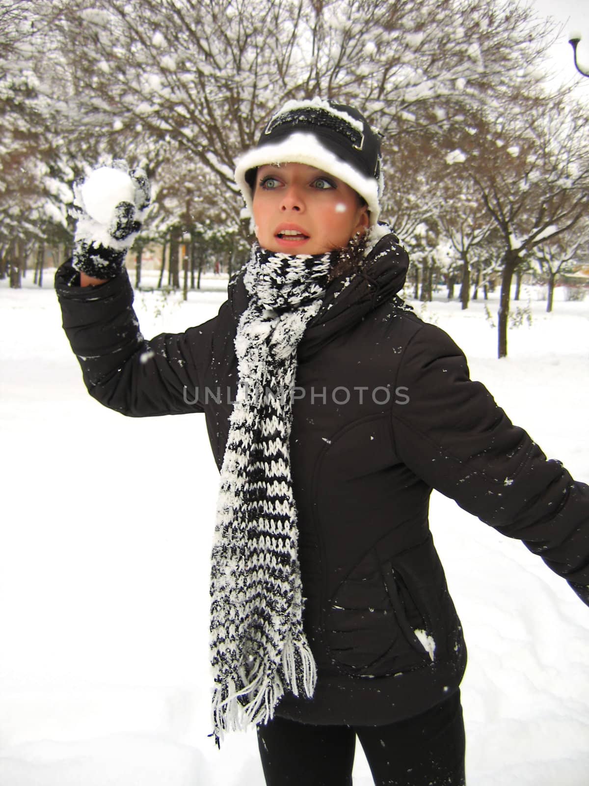 Girl playing snowballs on winter background