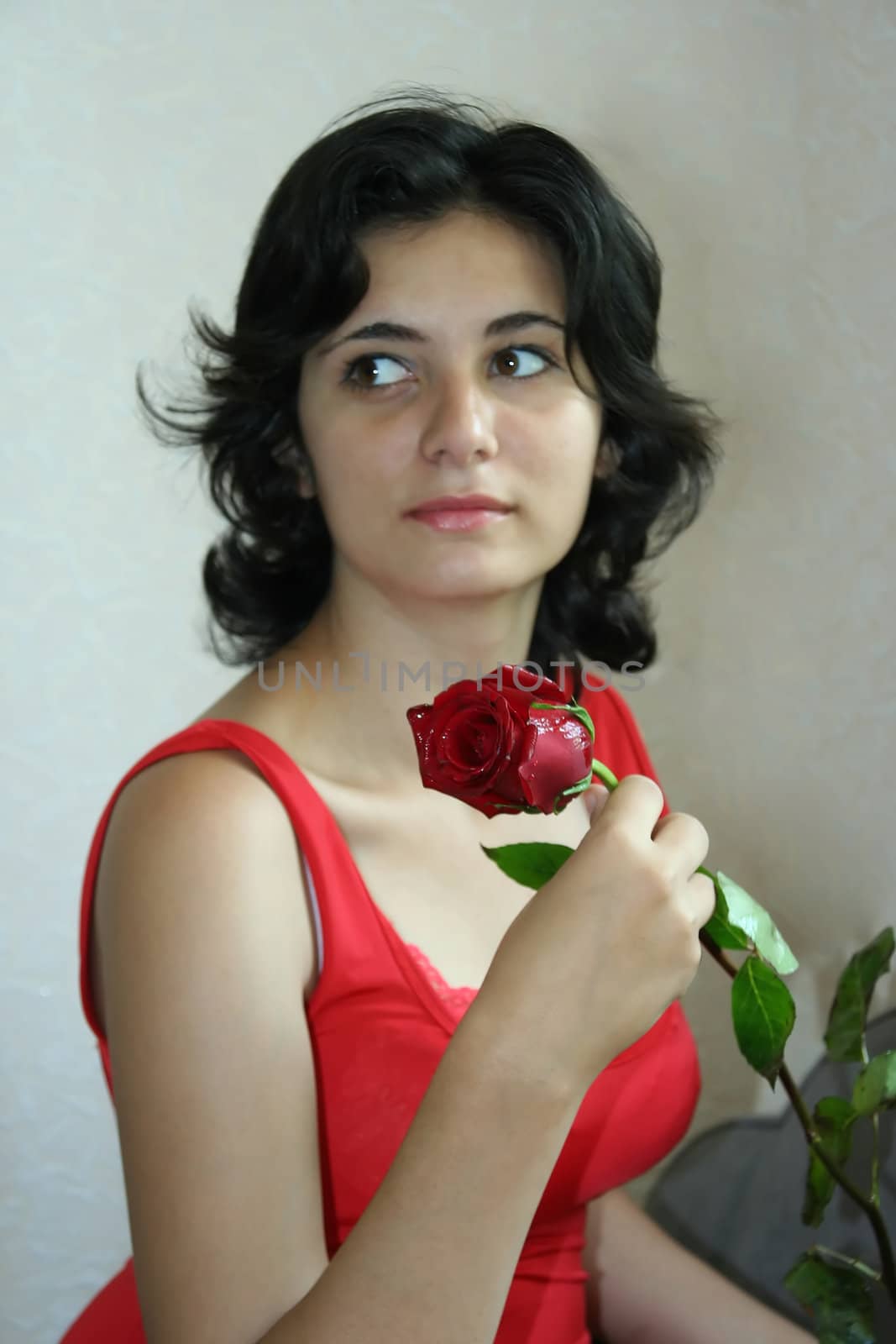 The beautiful girl holds a scarlet rose