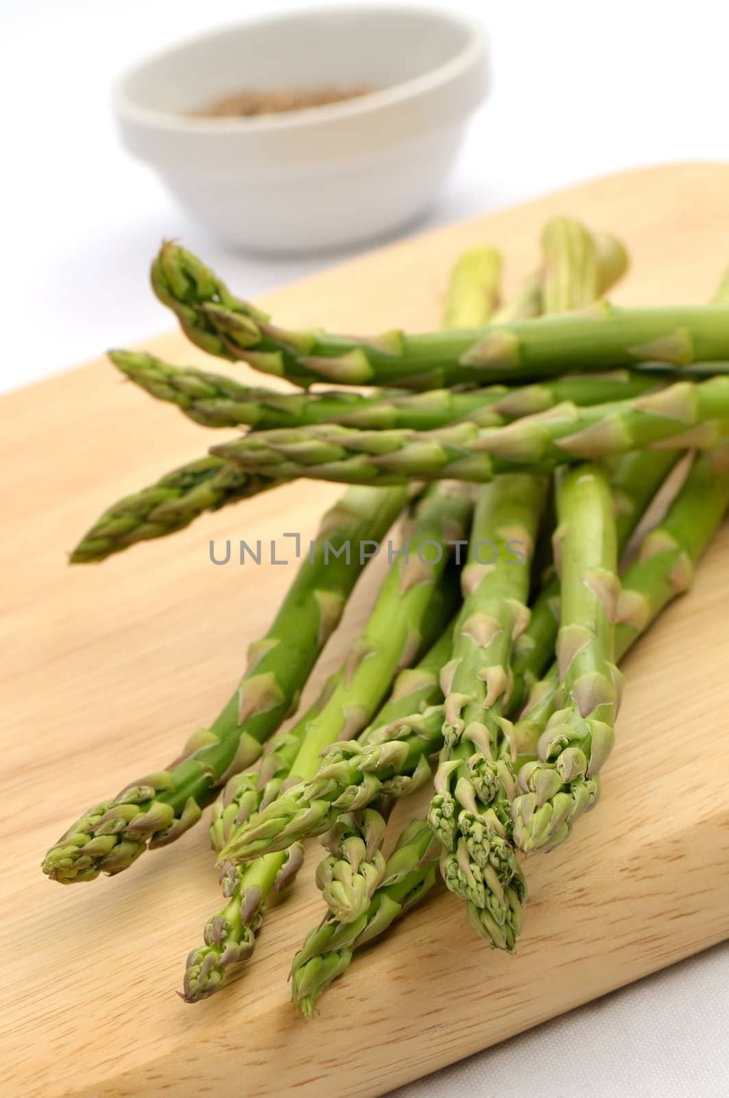 Raw asparagus on a chopping board. Shallow depth of field. Focus on front tips