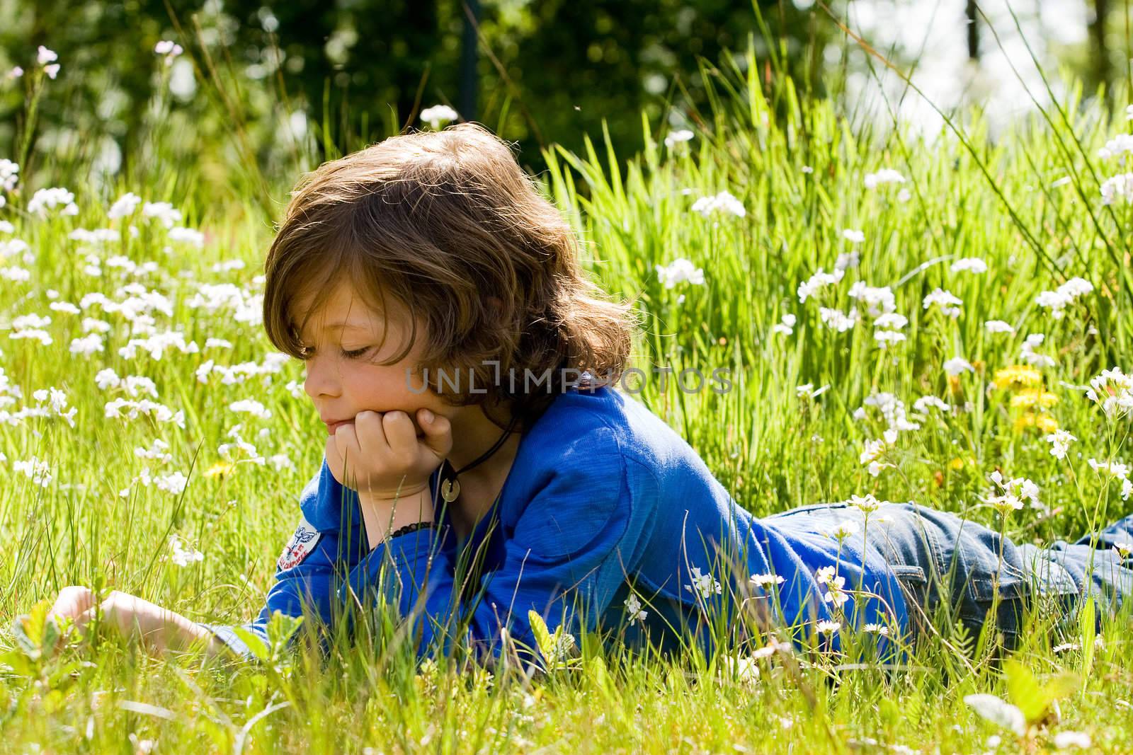 Young boy is thinking in the grass