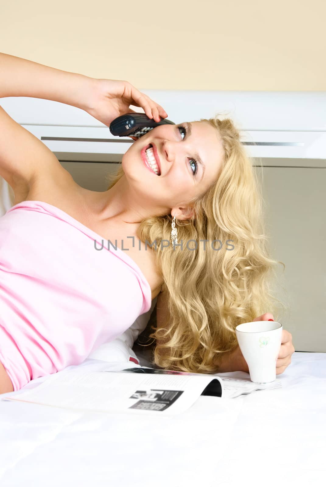 beautiful blond girl talking on the phone and drinking coffee