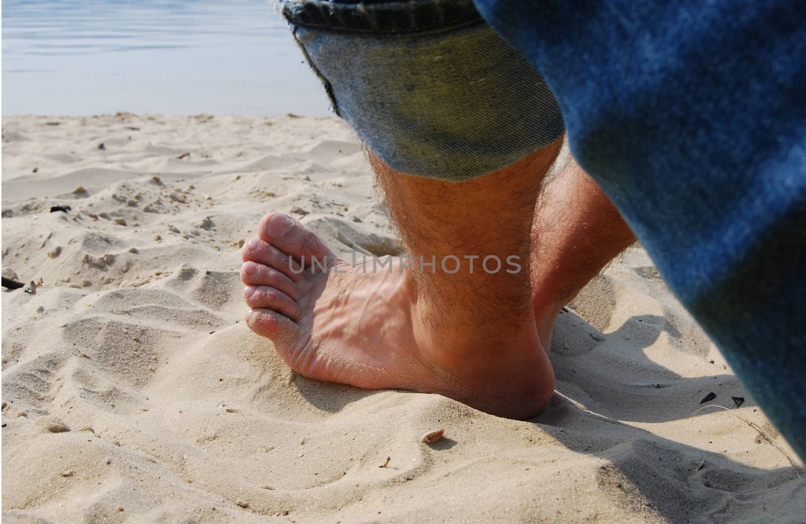 man foot on sand under the sunlight