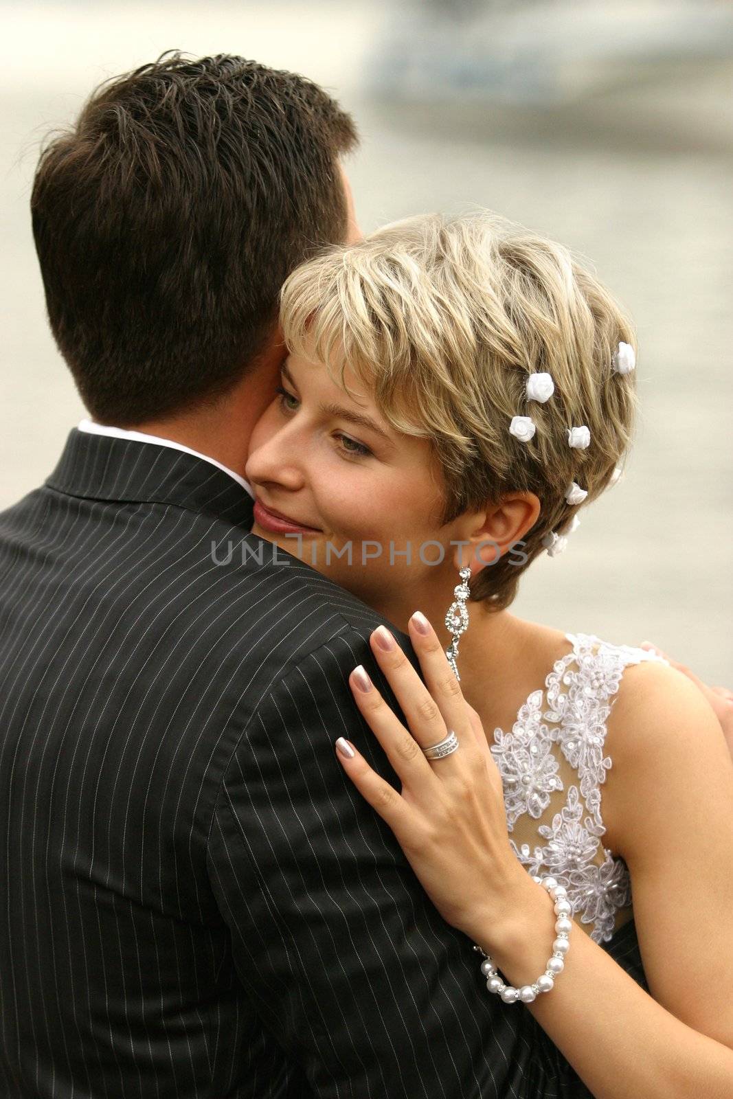 The bride with a smile, gently embraces the groom