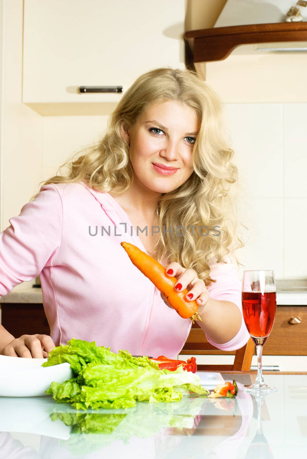 pretty blond woman making salad at home in the kitchen