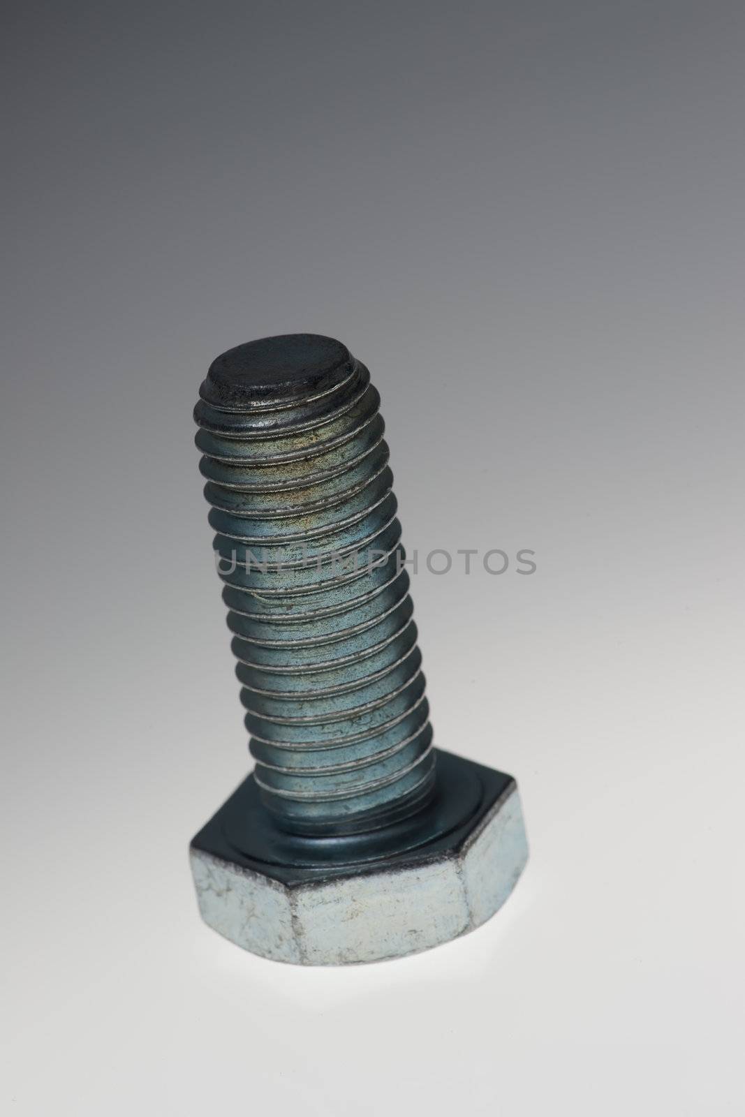 Extreme close up of a bolt over white grey background