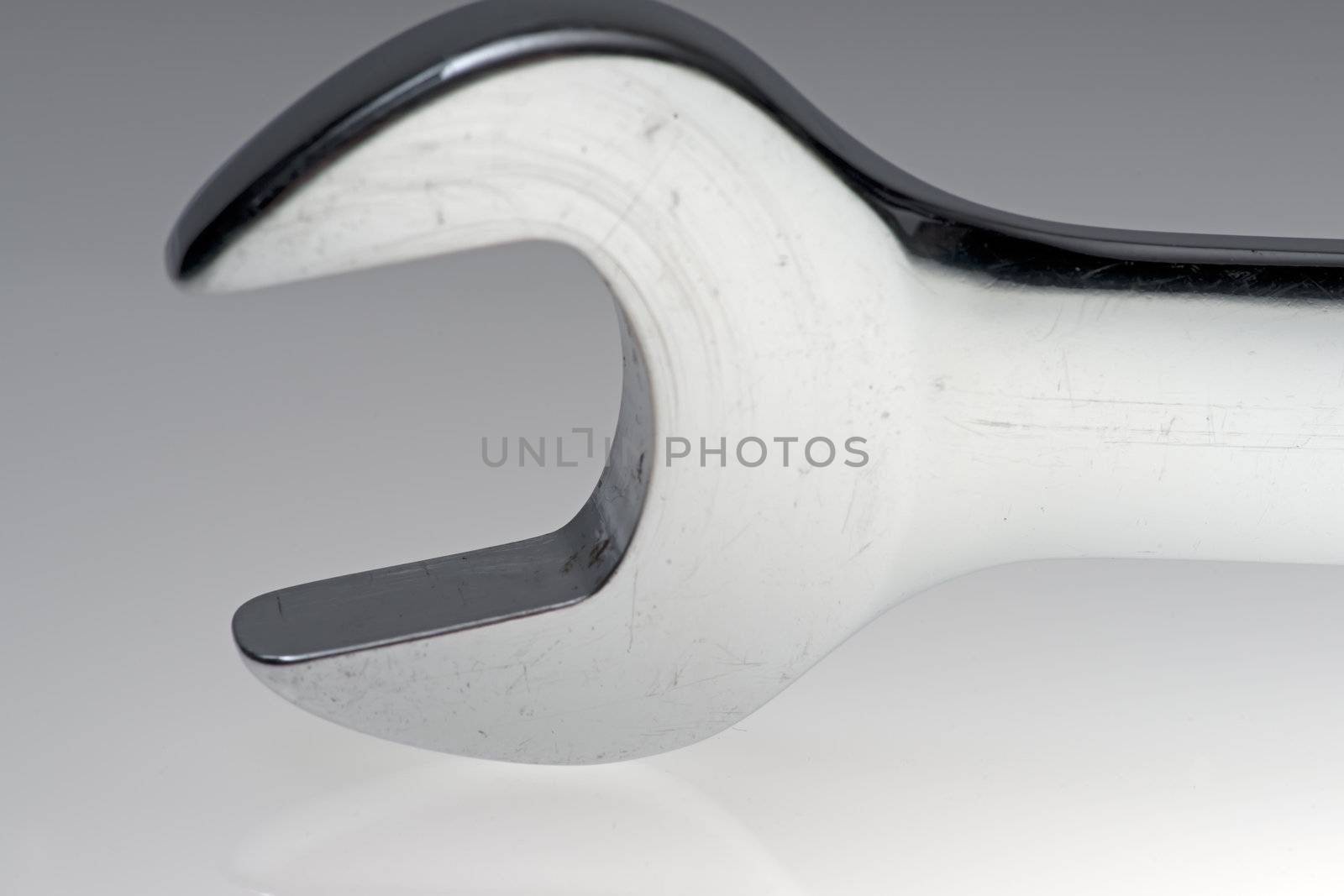 Extreme close up of a wrench head over white grey background