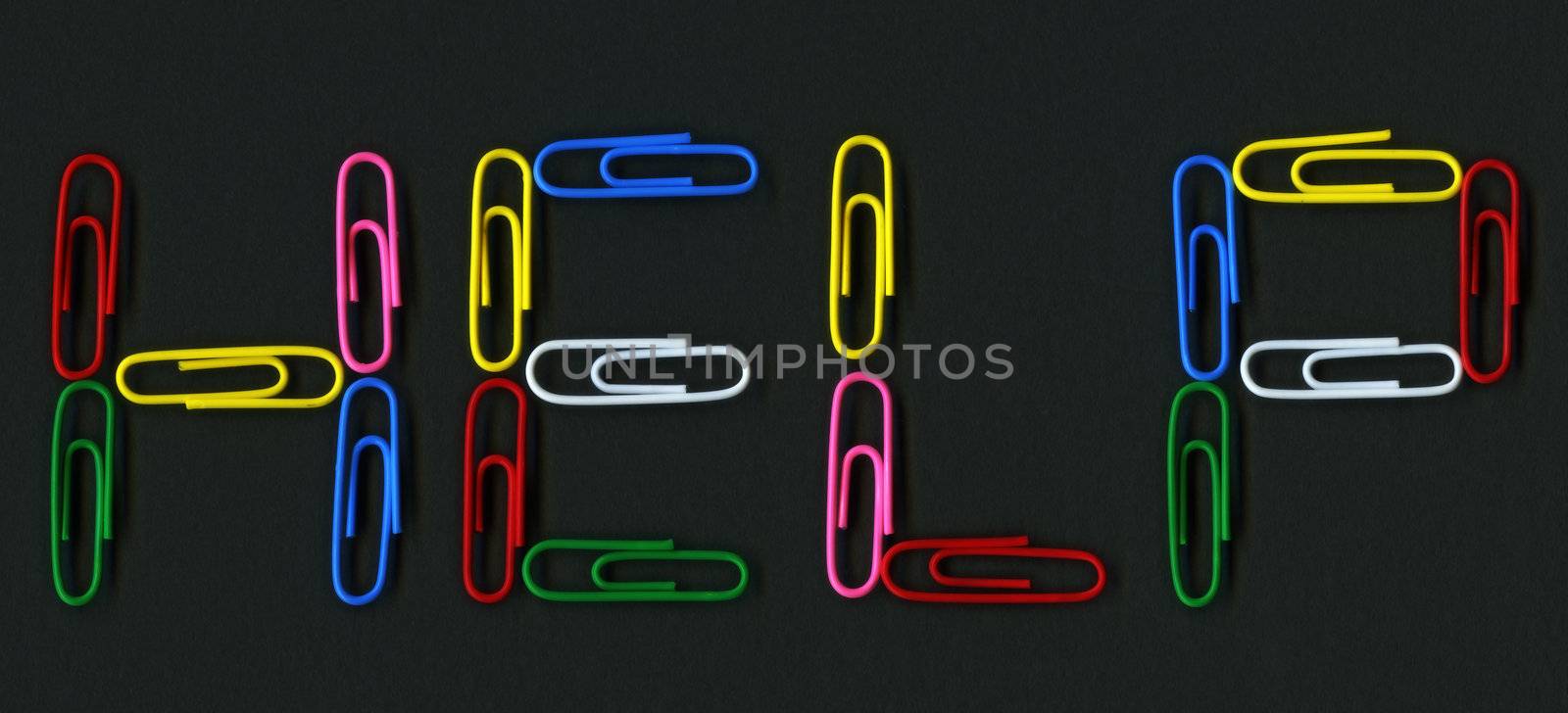 Multicolored paper clips spelling help over black background