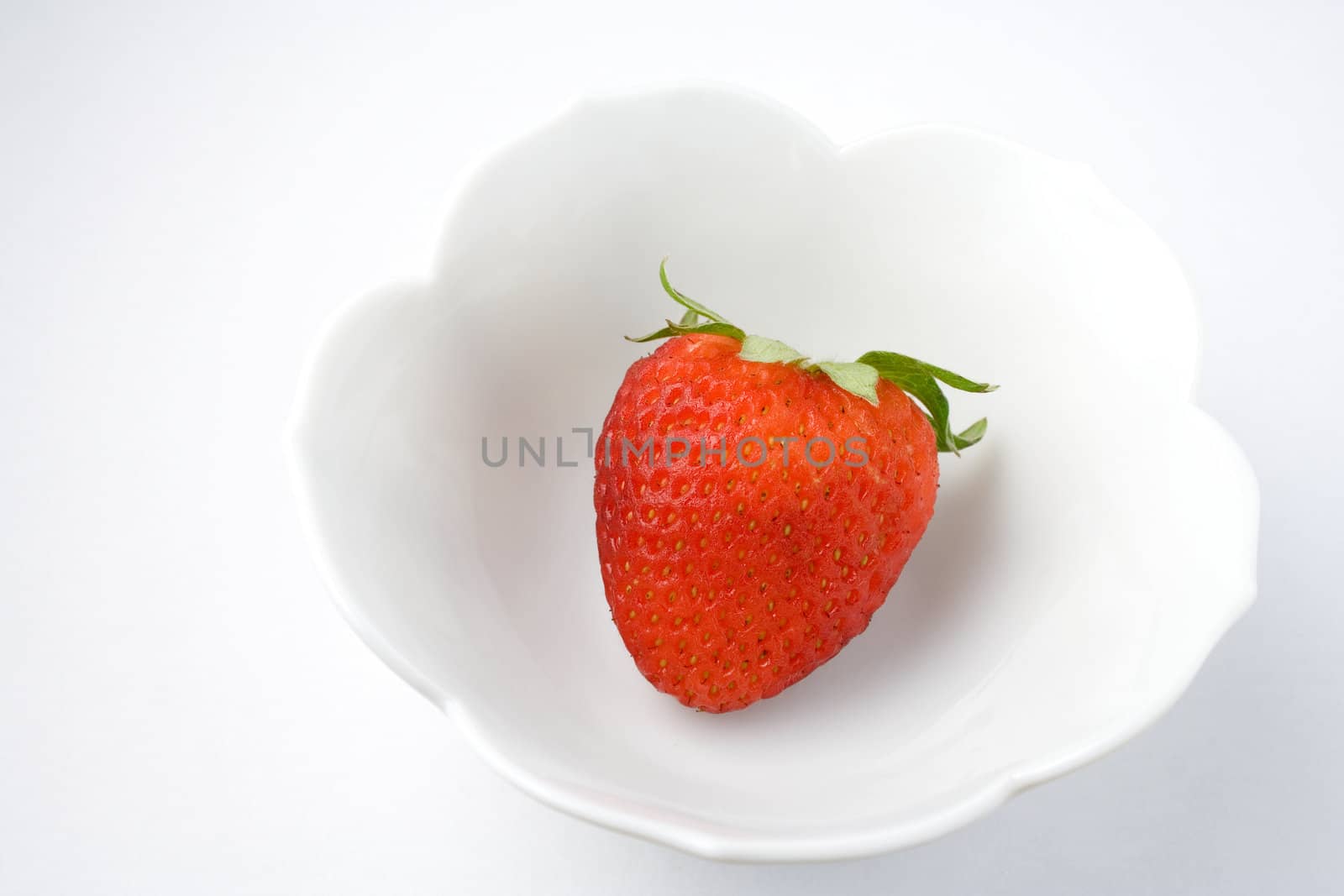 Single strawberry in bowl for healthy eating