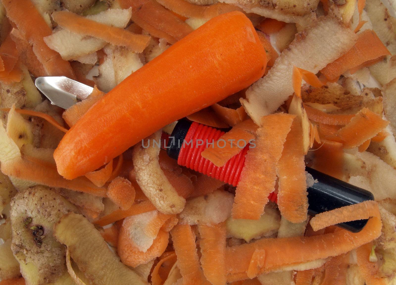 Vegetable scraper with carrot and potato peelings .