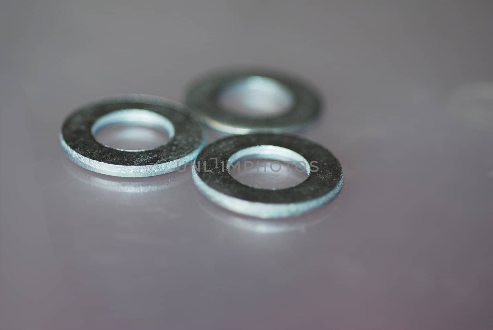 An extreme close-up photograph of three washers for household repairs