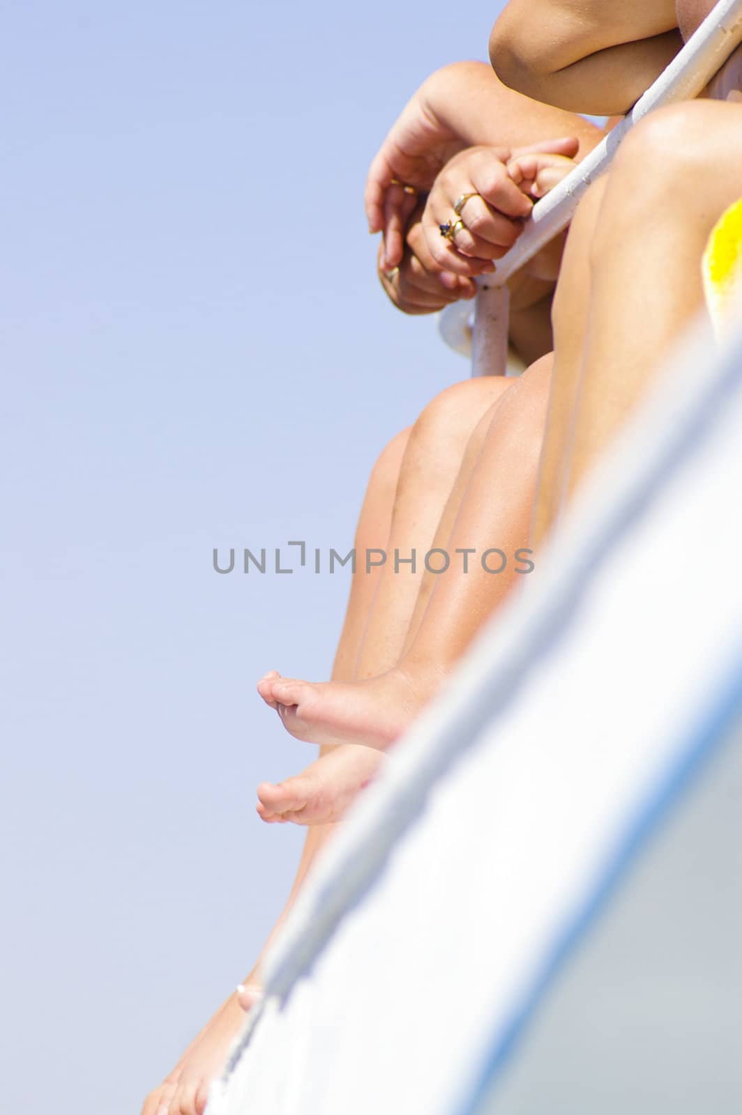 Girls legs on boat on vacation at sunny day