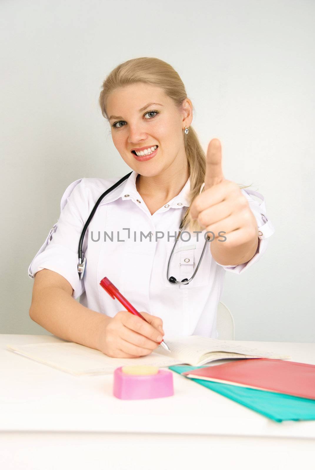 portrait of a young beautiful doctor with her thumb up