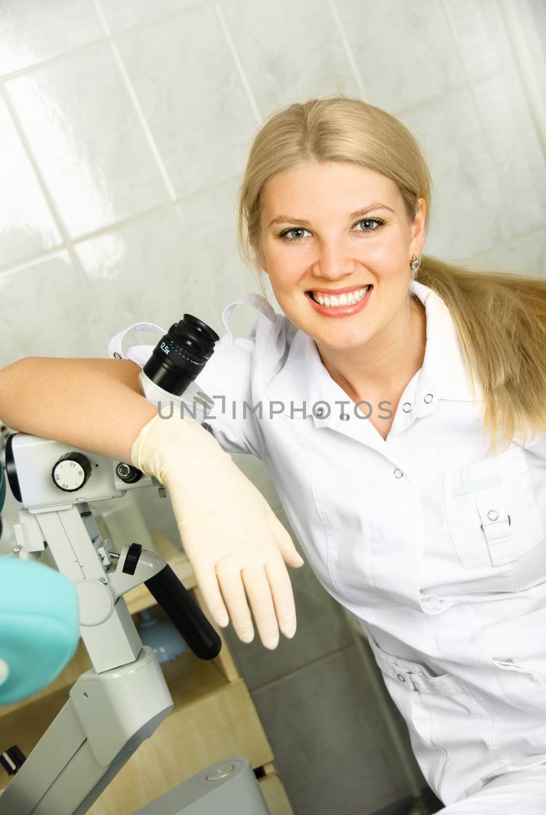 beautiful young gynecologist with a colposcope in her office