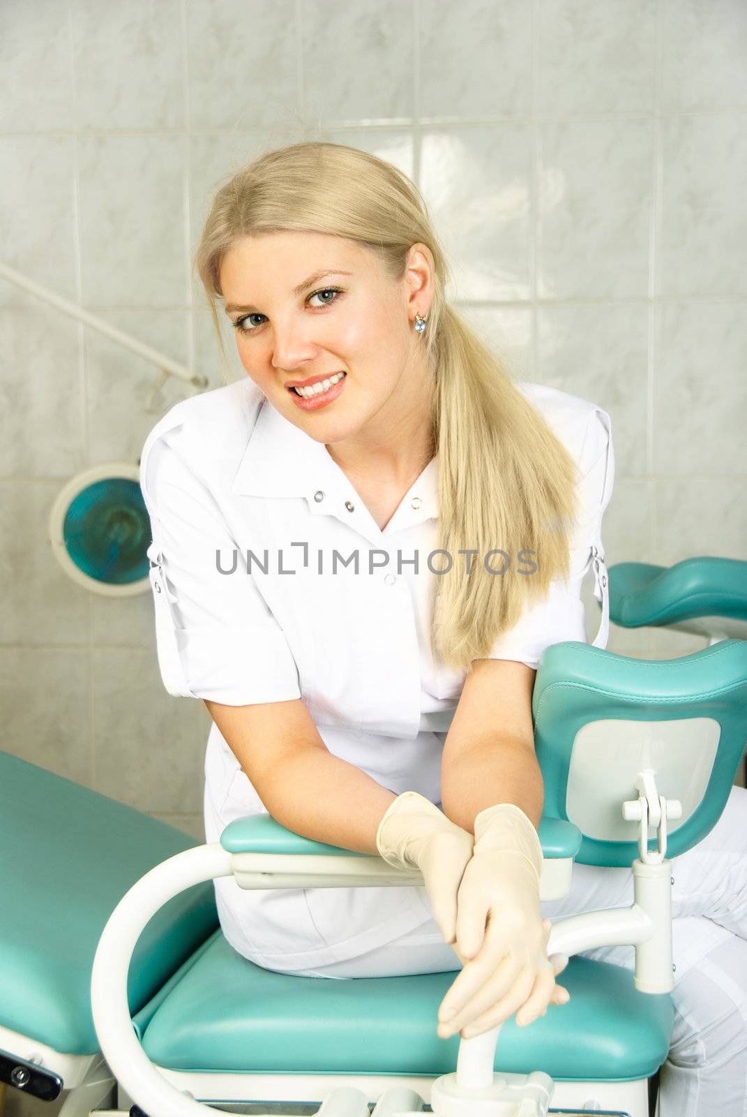 beautiful young doctor sitting on the gynecological chair in her office