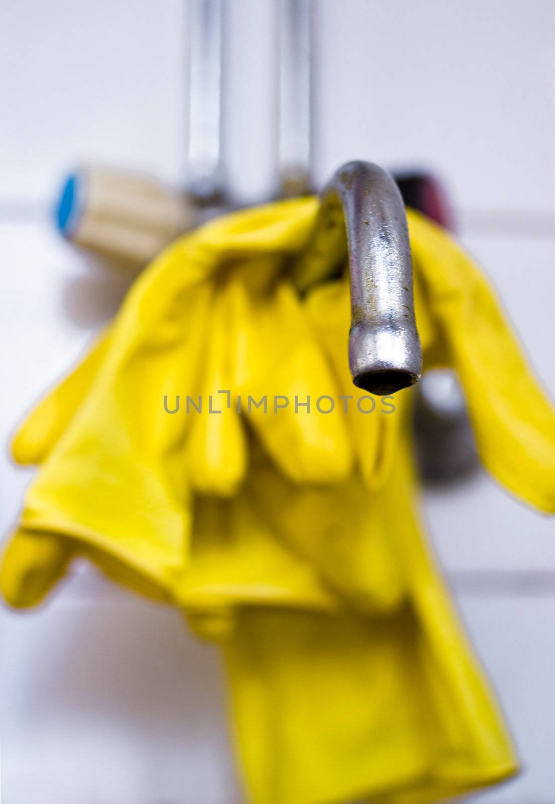 Yellow glove placed on faucet waiting for cleaning