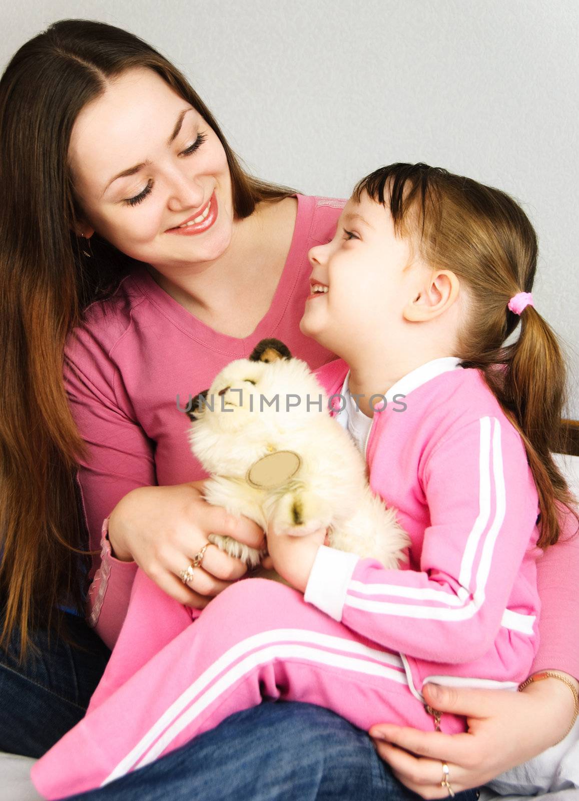 young beautiful mother and her little daughter embracing and talking 