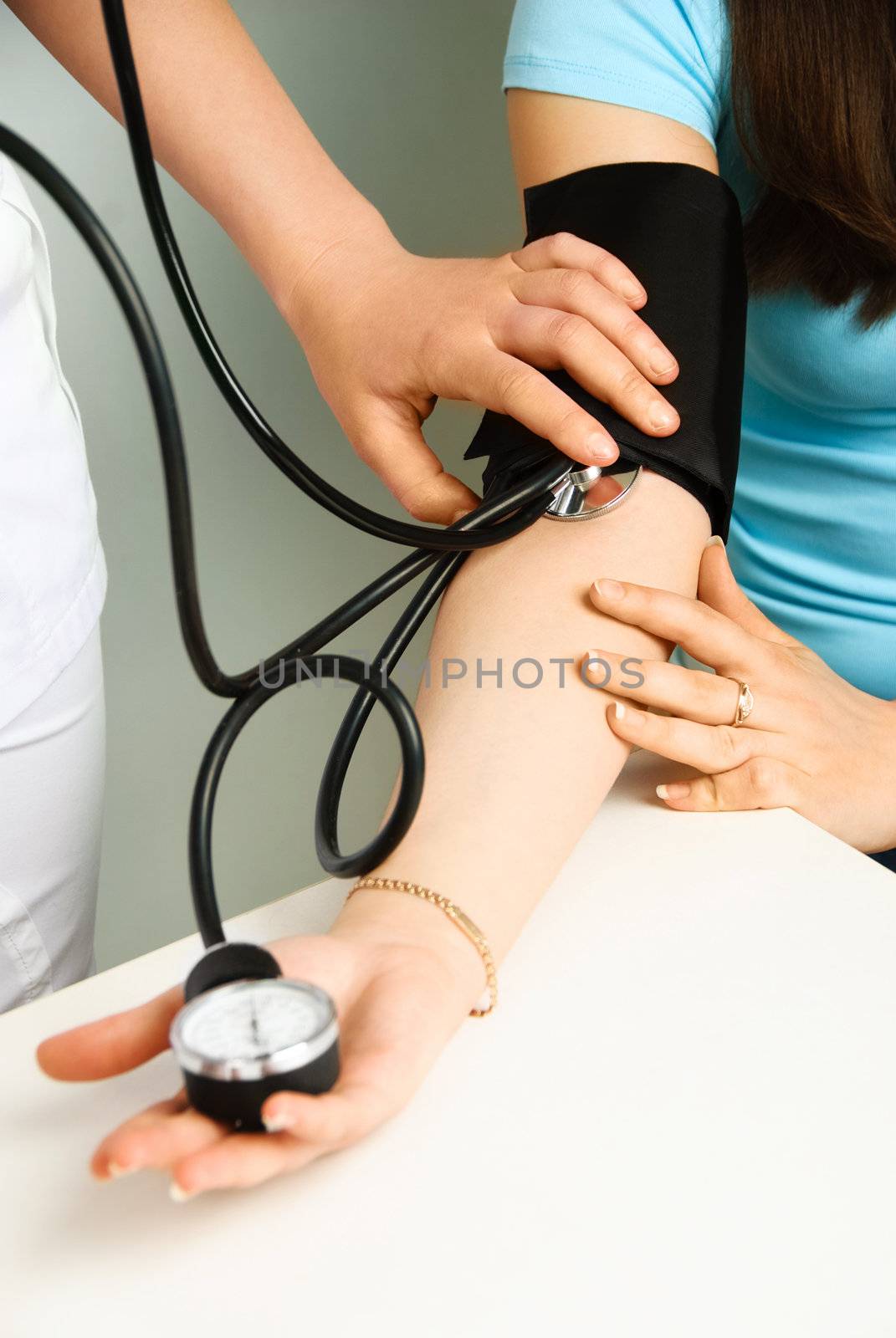 closeup of the hands of a doctor measuring  blood pressure of a patient 